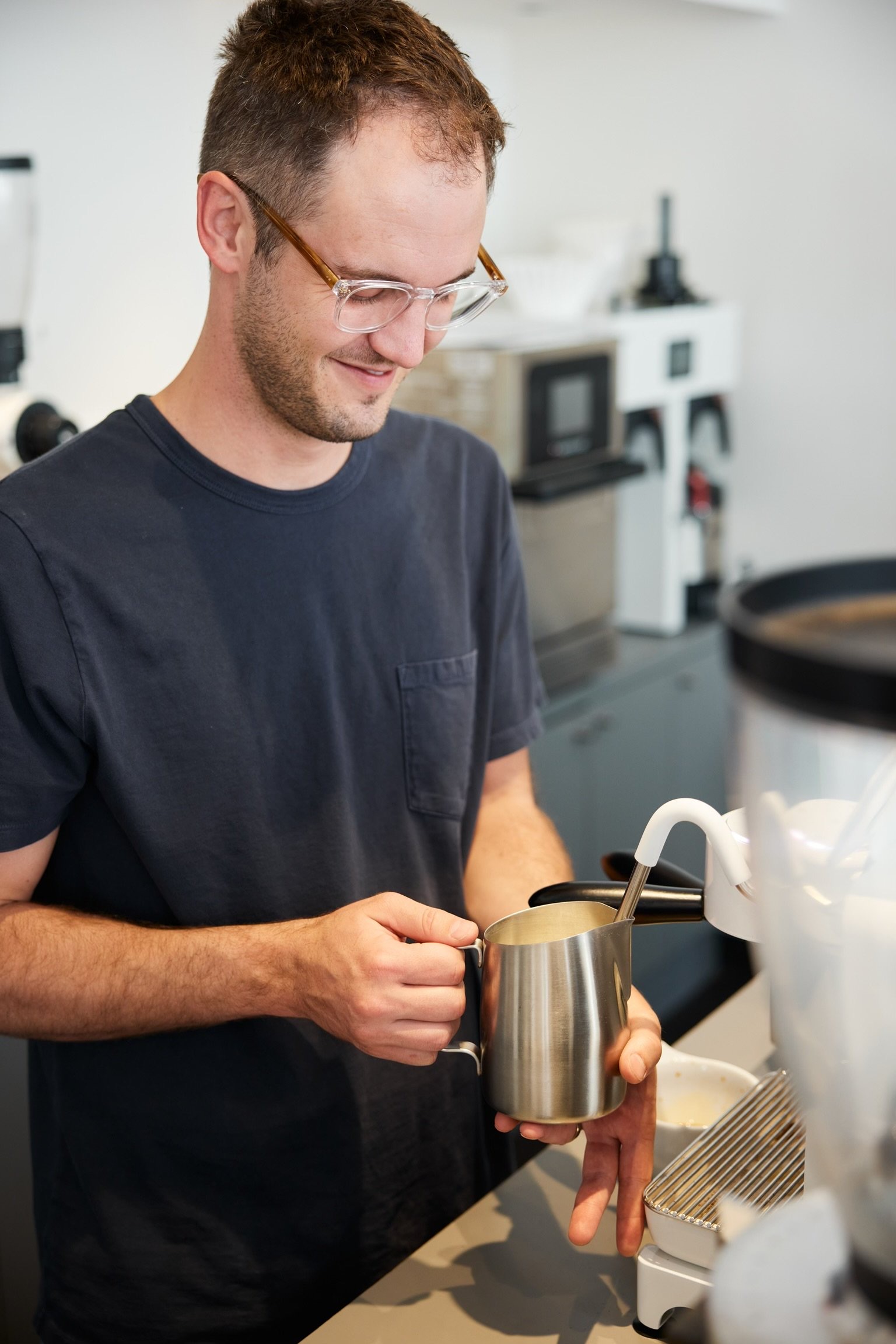 A barista steaming milk at the espresso bar.